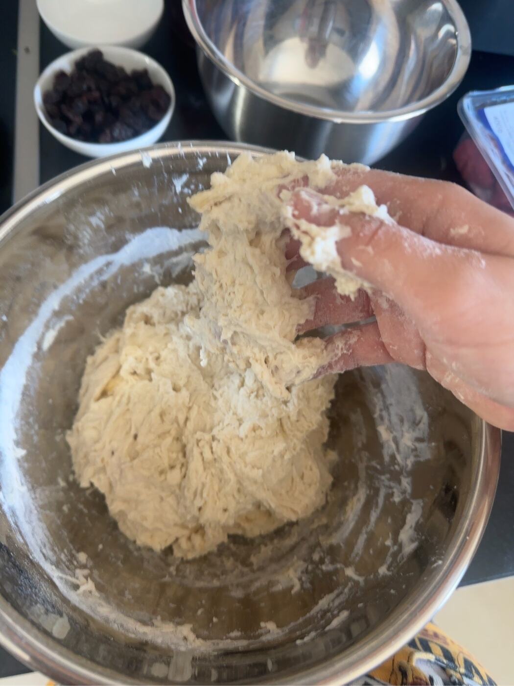 Sticky homemade naan dough being mixed by hand.