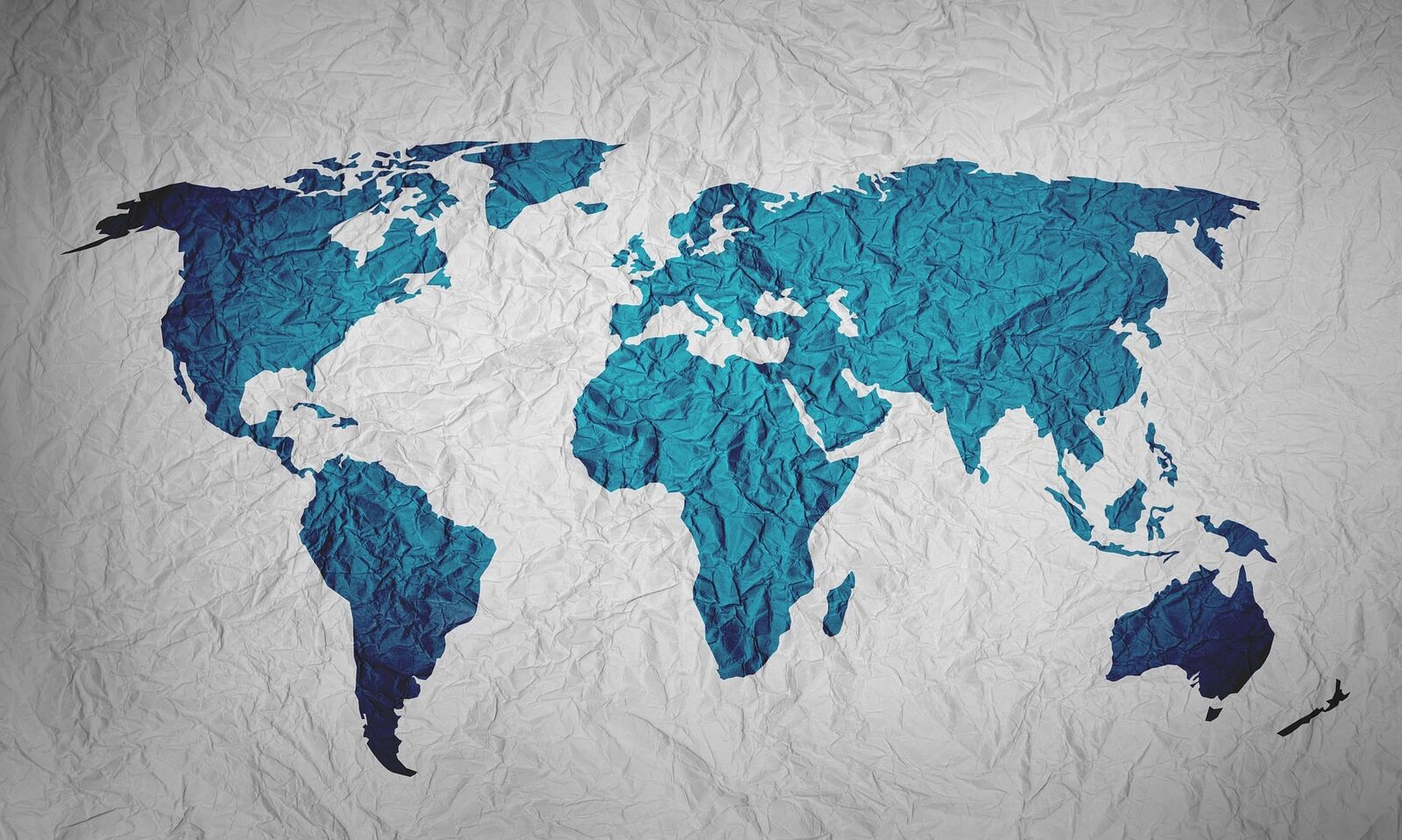 Blue world map on a textured white paper background