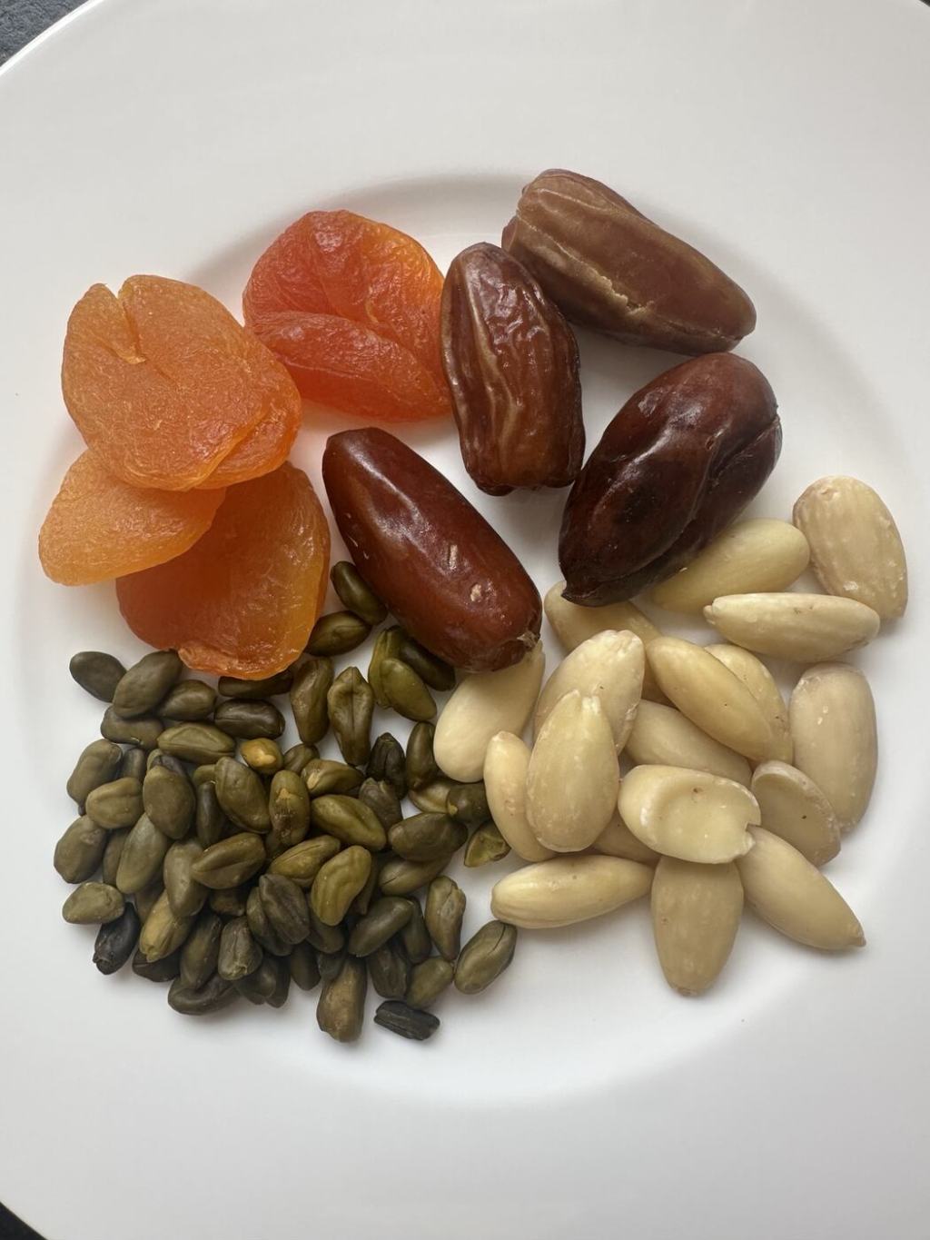 Dates, dried apricots, almonds and pistachios served with black tea.