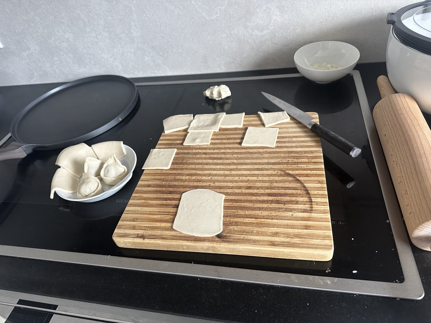 Homemade Mantu wrappers and folded dumplings during preparation.