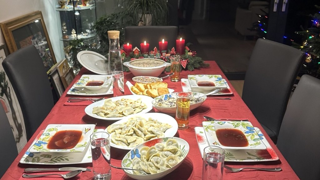 A Polish Christmas Eve table set with pierogi, barszcz and festive dishes